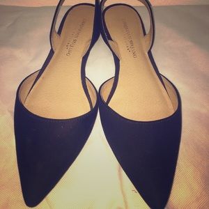 Black pointed flats with strapped heel.
